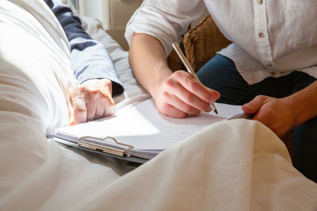 A caregiver's supportive interaction with a senior in a sunlit room, highlighting care and connection.