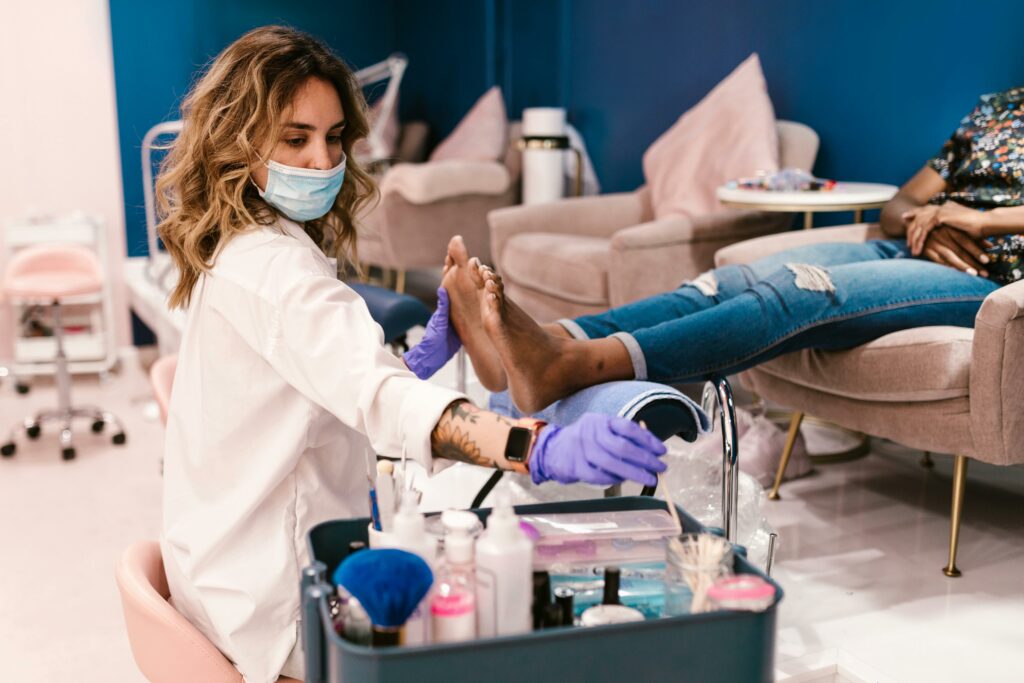 A beautician performs a pedicure on a client in a modern salon setting.